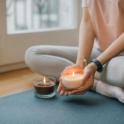 A close-up of hands in a meditative pose in a softly lit room.