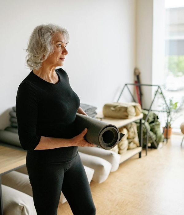 A person in a calm, spacious room with soft lighting, preparing for exercise.